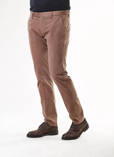 Мужская модель позирует в светло-коричневых брюках и коричневых туфлях в легкой студии — стоковое фото