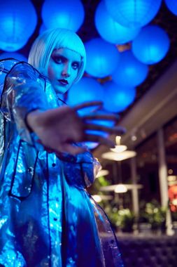 Fütüristik neon ışıklı ipeksi bluz ve şeffaf yağmurluk, kağıt fenerler arka plan üzerinde beyaz bob saç modeli ile inanılmaz bir kadın portresi