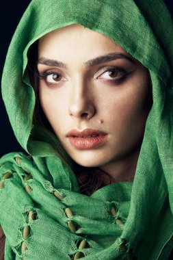 Yakın çekim yeşil hijab giyen çekici Doğu ve kadın ile güzel koyu renk gözleri, büyük dudaklar dudak, yakınındaki doğum lekesi portresi. 