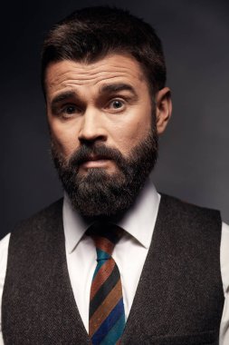 Stüdyo portre siyah saçları ve bıyığı beyaz gömlek, kahverengi yelek, renkli kravat ile ciddi çekici biri. Eski moda stil, beyefendi.