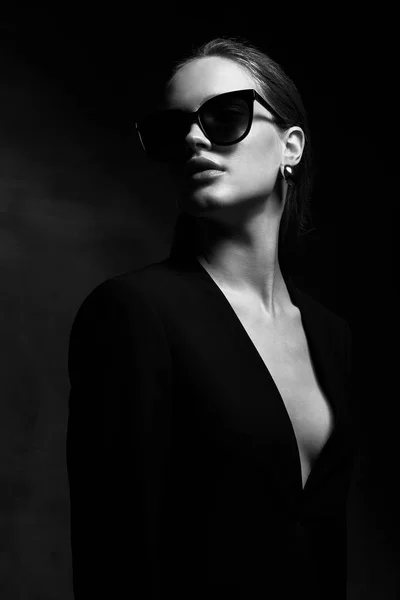 黑色深 颈夹克和深色太阳镜的年轻漂亮女子性感典雅黑白肖像 — 图库照片
