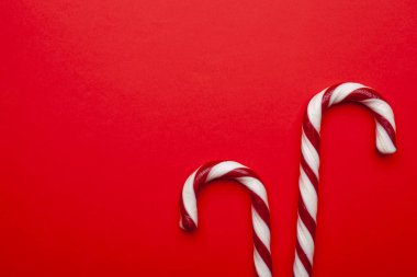 Kırmızı arka planda Noel şekerleri. Metin için boşluk olan üst görünüm. En düşük bileşim