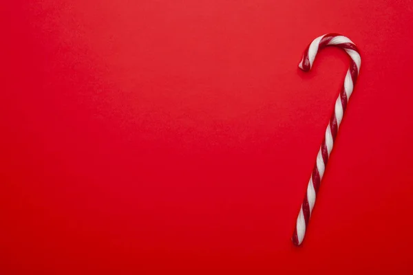 Kırmızı arka planda Noel şekeri kamışı. Metin için boşluk olan üst görünüm. En düşük bileşim