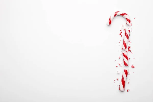 Beyaz arka planda kırık Noel şekeri kamışı. Nane şekerli en düşük kompozisyon. Düz konum, metin için boşluk ile üst görünüm