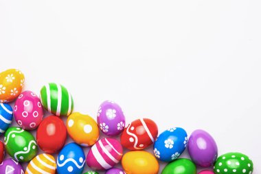 Paskalya yumurtalarının açık arkaplanda olduğu düz bir kompozisyon. Süslü yumurtadan yapılmış çerçeve. Metin için yeri olan üst görünüm