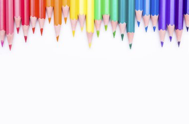 Beyaz arka planda farklı renkli kalemler. Renkli kalemlerle yapılmış çerçeve, yakın plan görünümü, metin için boşluk