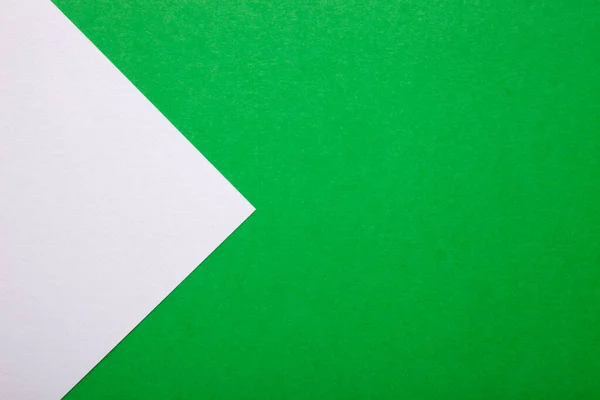 Green and white paper as background. Two colored bright paper texture, top view with place for text