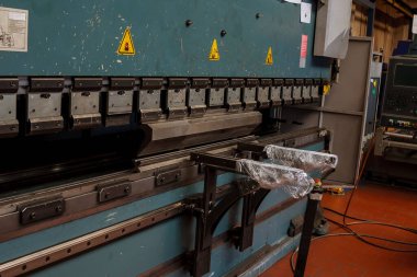 Fabrikada hidrolik makineyle metal bükme levhası.