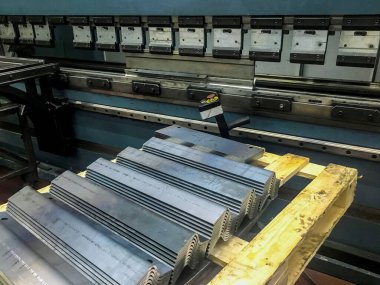 Metal levha bükme makinesiyle fabrikada bükülüyor..