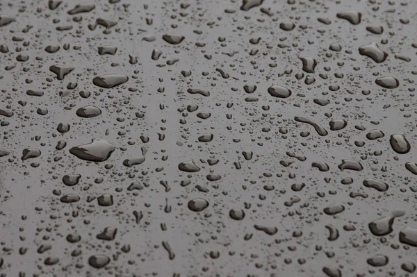 Gocce d'acqua sulla macchina. Contesto. Gocce di pioggia su metallo . — Foto Stock