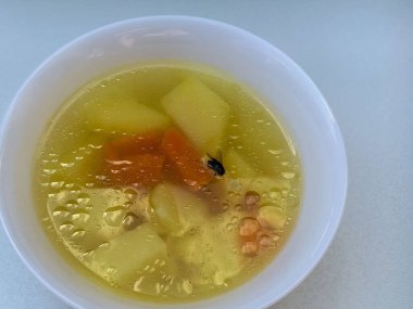 Beyaz tabakta sebze çorbası..