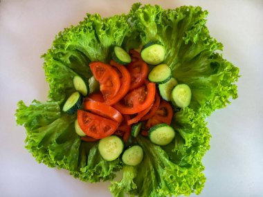 Taze sebzeler. Marul yaprakları, domates, salatalık. Beyaz arkaplan.