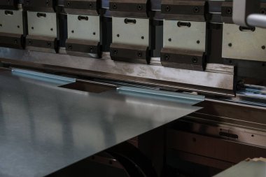 Fabrikada hidrolik makineyle metal bükme levhası.