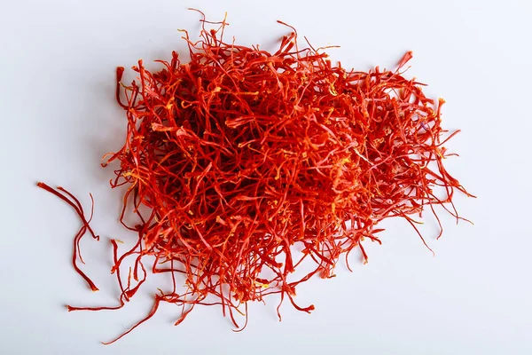 Pile de fils de safran rouge isolés sur un fond blanc. Chère épice . — Photo