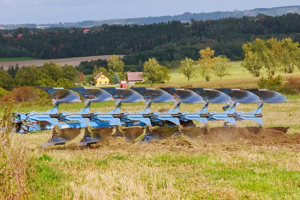 Landwirt mit rotem Traktor bereitet Land mit Pflug für die Aussaat vor — Stockfoto