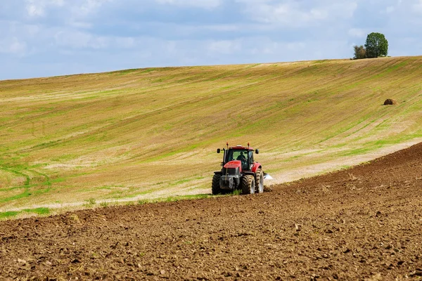 Boer op een trekker ploegt het land voor het zaaien met een zaaibed cultivator — Stockfoto