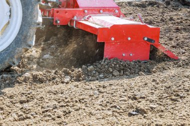 Çiftçi tarlayı sürüyor. Tarlada sabanı olan küçük bir traktör. Topraklama.