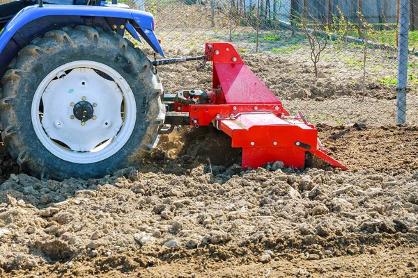 Farmář orá pole. Malý traktor s pluhem v poli. Pěstování. — Stock fotografie