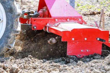 Çiftçi tarlayı sürüyor. Tarlada sabanı olan küçük bir traktör. Topraklama.