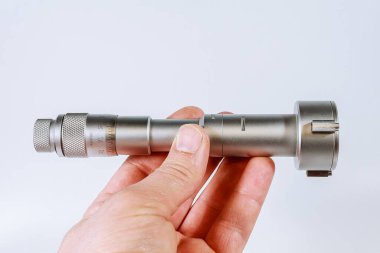 Beyaz zemin üzerinde üç noktalı mekanik mikrometre.