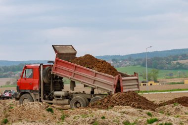 İnşaat alanına toprak veya kum boşaltan çöp kamyonu.