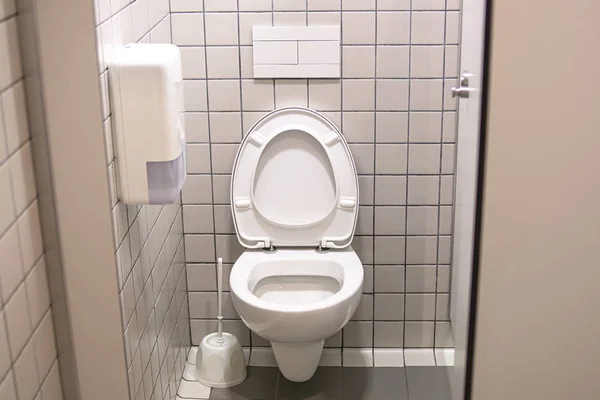 Weiße Toilette an der Wand aufgehängt, mit Wassereinleitungen Emb — Stockfoto
