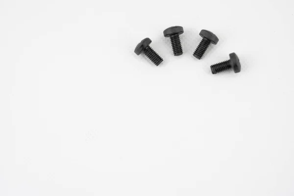 Black metal screws arranged in semicircle on white background — 스톡 사진