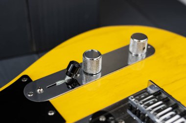 Volume, tone and switcher controls of a classic yellow and black