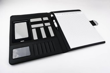 Siyah deri bir klasörde, içinde kalem olan bir not defteri.