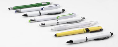 Beyaz arkaplanda farklı biçimlerde ve biçimlerde kalemler