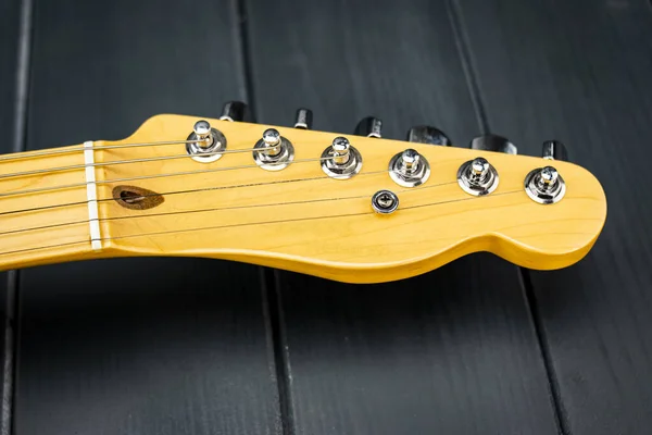 Pırıl pırıl ahşap gitar başlığı, akort tuşları ve krom vidaları var.
