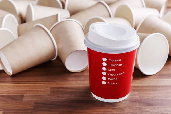Чашка кофе из красной бумаги на фоне бумажных стаканчиков — стоковое фото