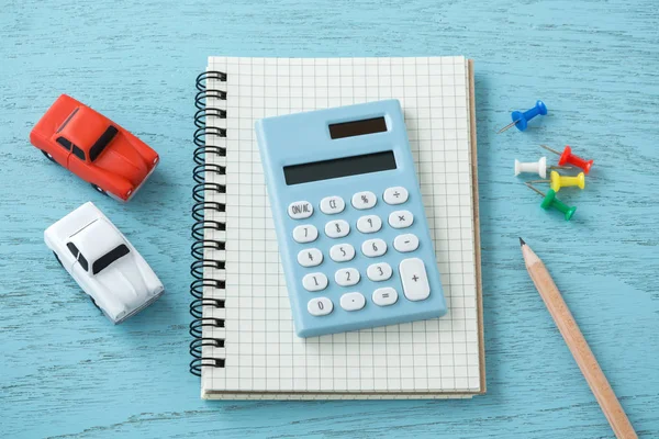 Calculator on notebook with toy cars — Stock Photo, Image