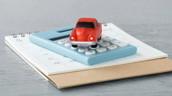 Toy car on caculator and calendar — Stock Photo, Image