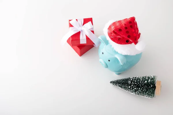 Piggy bank wearing christmas hat with decor on white background — Stock Photo, Image