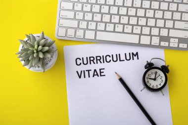 Sarı arkaplanda klavye ve saate sahip Cv
