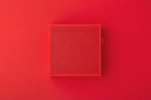 Red wireless speaker on red background