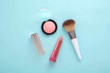 Mavi arka planda pembe ruj, allık ve fırça.