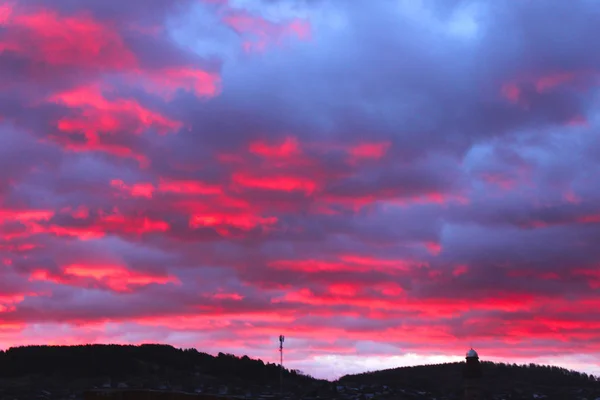 Красно-синий закат над городом покрыт облаками. Городской силуэт с прекрасным закатом. Художественно размытое . — стоковое фото