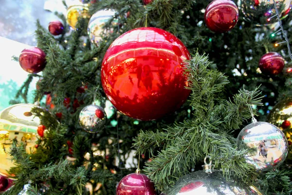 Close-up of an elegant Christmas tree. A large Christmas red ball surrounded by other balls on a Christmas tree. Festive christmas background — Stock Photo, Image