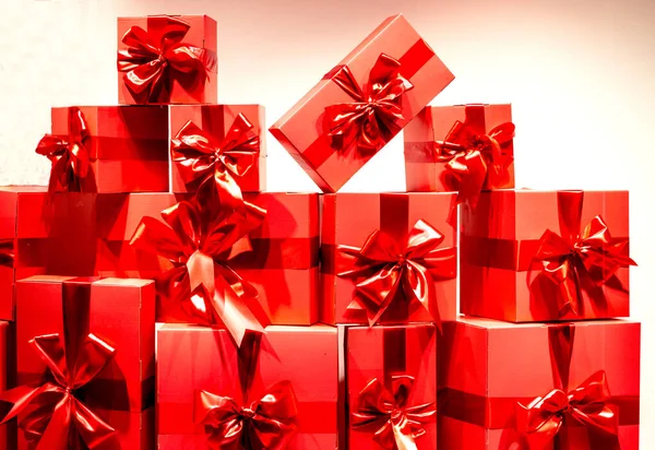 Viele rote Geschenkboxen mit Bändern auf weißem Hintergrund. ein Bündel von Geschenken in heller, festlicher Verpackung — Stockfoto