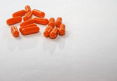 Beyaz kağıda dağılmış turuncu haplar. Özel tekliflerin planı, reklamcılık, internet geçmişi. İlaç, eczane, sağlık hizmetleri kavramı. Mesaj ve logo için boş alan. Yakın çekim, uyuşturucuların tecrit edilmesi