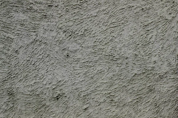 Texture gray plastered wall for background. Rough cement wall plaster. Facade stucco background. The exterior of the building. Cement-sand cement plaster