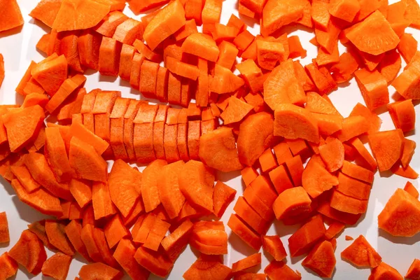 Chopped and chopped carrots. Fresh diced carrots on a white background. Carrot slices on a white background. The concept of proper nutrition, raw food diet, healthy food.