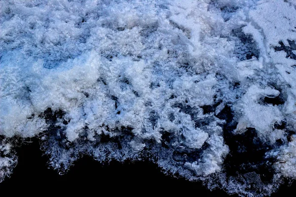 Pintoresca hoarfrost, cristales en el hielo del río sobre el agua oscura. Oscuro y claro hermoso. La estructura de nieve y hielo. Primer plano. Enfoque selectivo y suave . — Foto de Stock