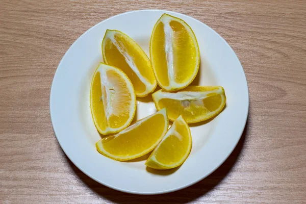 Нарезанный лимон на белой тарелке на деревянном фоне. Вид сверху. Кусочки лимона для свежего . — стоковое фото
