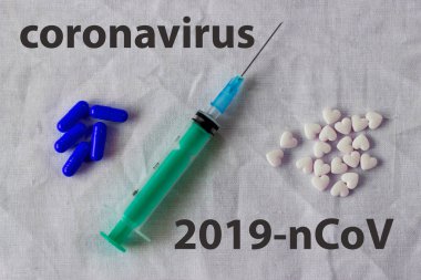 Mavi haplar, şırınga ve beyaz buruşuk medikal dokuda kalp şeklinde küçük haplar. Kopyalama. Virüs ve grip için ilaçlar. Coronavirus hastalığı 2019