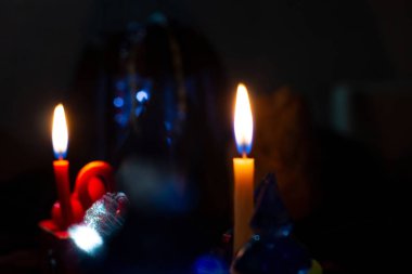 Kehanet dansı, büyü, kehanet, gece ayini. Gizem için yumuşak odak. Karanlıkta mumları sihirli aletlerle yakmak, uzayı kopyalamak. Sanatsal olarak bulanık.