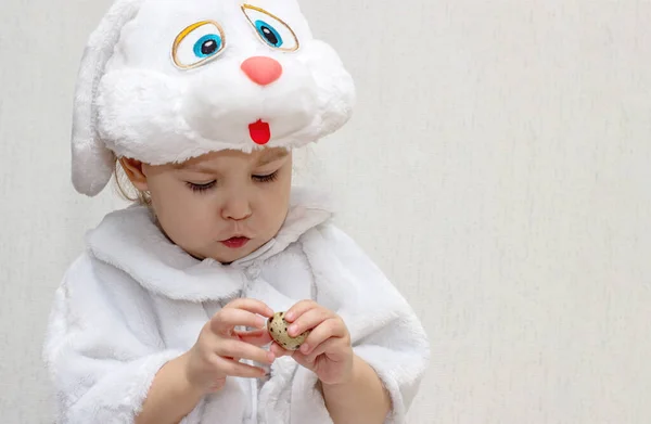Holčička Bílém Králičím Kostýmu Čistí Křepelčí Vejce Světlém Pozadí Dítě — Stock fotografie