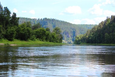 Ormanın içinden akan bir nehir. Uzakta bir dağ ormanı, mavi bir sis, nehir suyu manzarası. Rusya, Güney Ural, Belaya nehri, rafting, seyahat